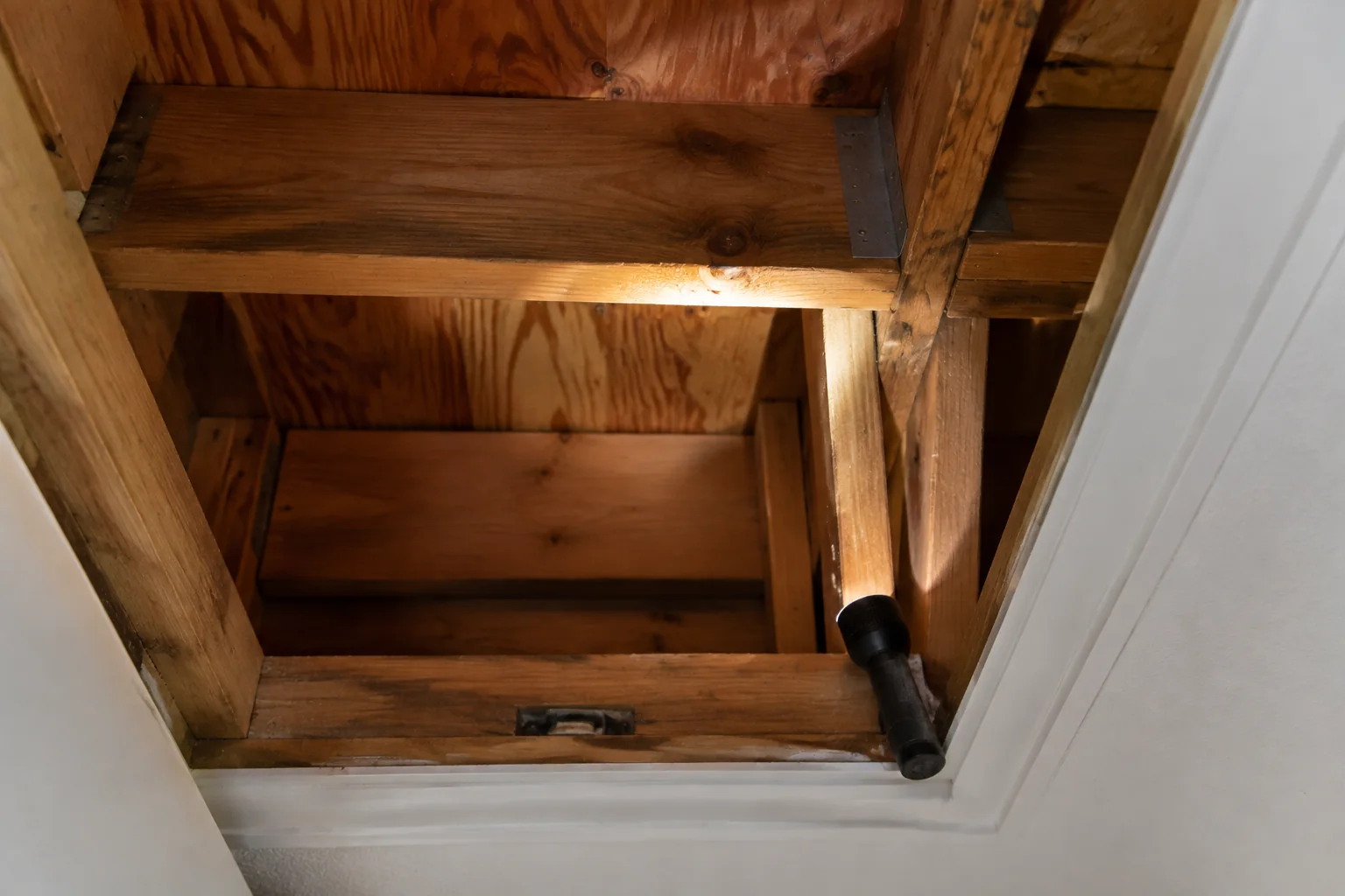 Inspection Services 13 Flashlight illuminating timber framing at an attic opening
